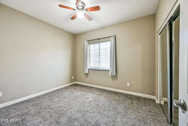 an empty room with windows and fan