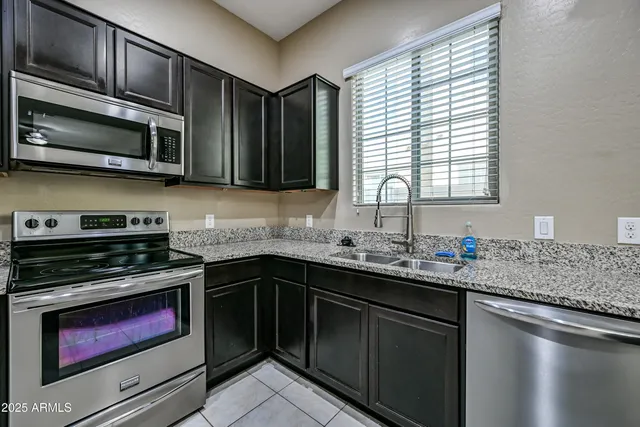a kitchen with stainless steel appliances a stove sink microwave and cabinets