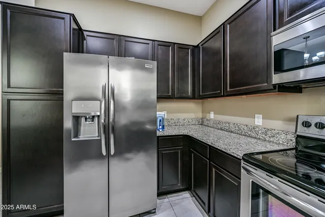 a kitchen with stainless steel appliances granite countertop a refrigerator and a stove top oven