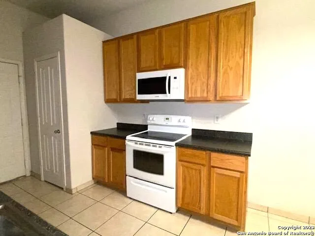 a kitchen with stainless steel appliances granite countertop a stove a microwave and a sink
