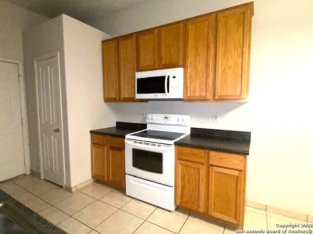 716 Uvalde Street, Unit B Pleasanton, TX 78064 - Photo 3 of 10 a kitchen with stainless steel appliances granite countertop a stove a microwave and a sink