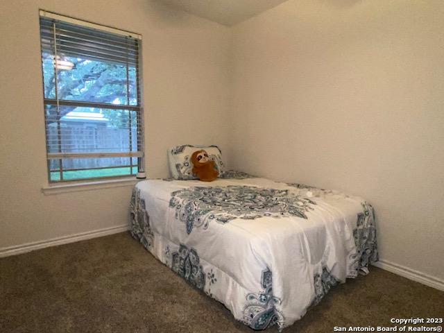 716 Uvalde Street, Unit B Pleasanton, TX 78064 - Photo 7 of 10 a large bed sitting in a bedroom next to a window