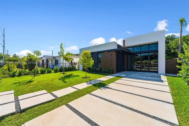 a front view of a house with a yard and a garage