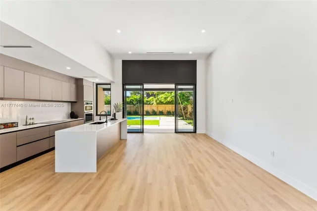 a living room with furniture a large window and wooden floor