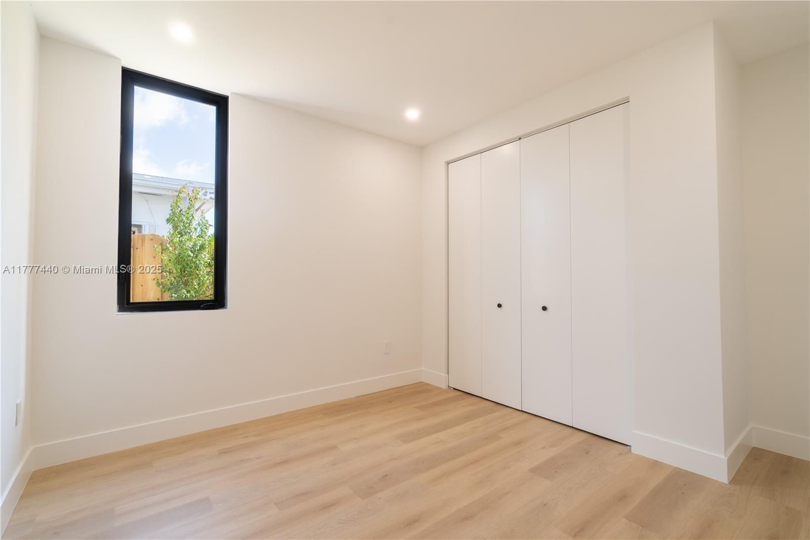 412 Northwest 47th Street Miami, FL 33127 - Photo 28 of 62 an empty room with wooden floor and windows