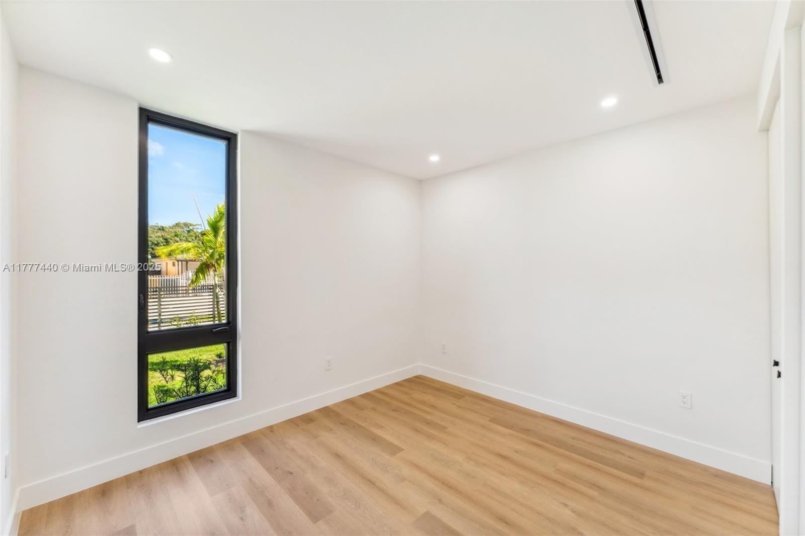 412 Northwest 47th Street Miami, FL 33127 - Photo 39 of 62 a view of an empty room with window and wooden floor