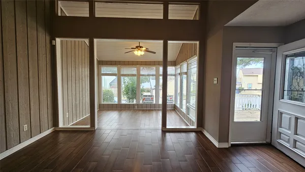 a view of an empty room with wooden floor and a window