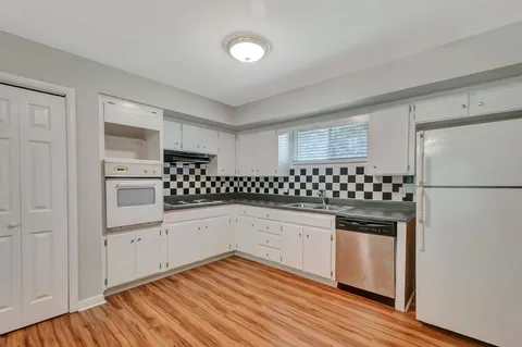 a kitchen with granite countertop white cabinets and white appliances