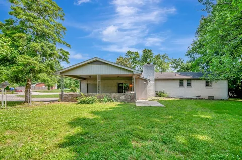a front view of a house with a yard and trees