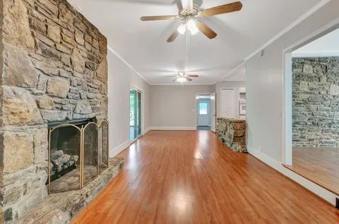 a view of a livingroom with wooden floor and a fireplace