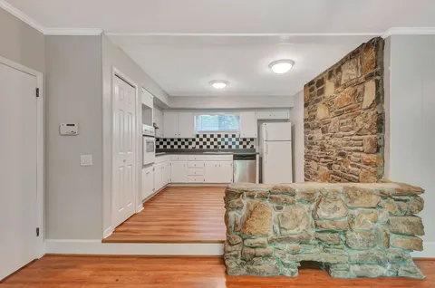 a view of a bedroom with wooden floor & a ceiling fan
