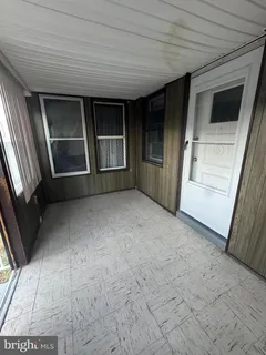 a view of an empty room with a fireplace and a window