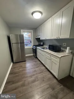 a kitchen with a sink a refrigerator and cabinets