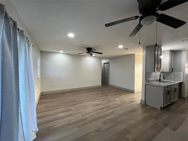 wooden floor in an empty room with a kitchen