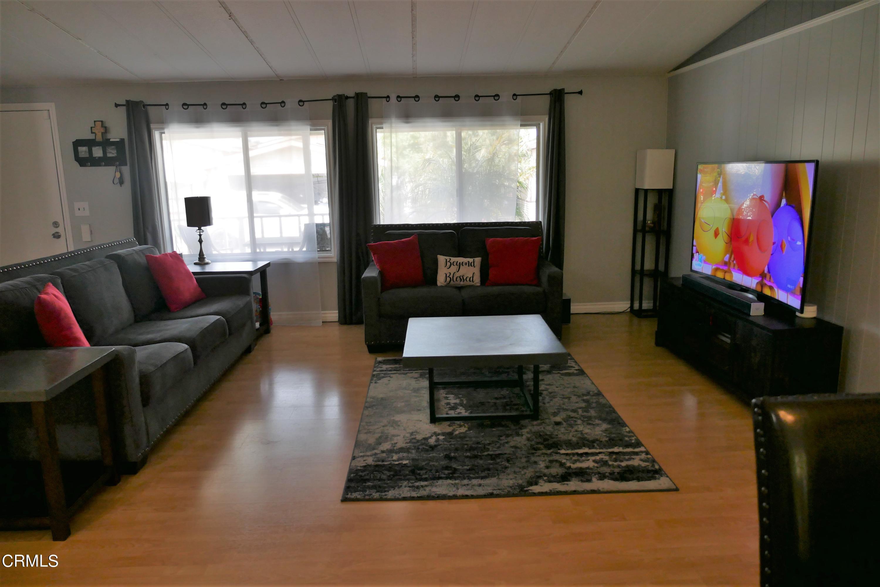 481 Raspberry Place, Unit 112 Oxnard, CA 93036 - Photo 8 of 18 a living room with furniture and a flat screen tv