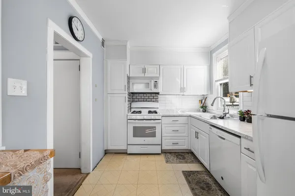 a kitchen with sink refrigerator and cabinets