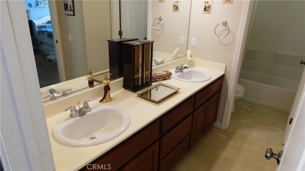 1216 Aups Court Merced, CA 95348 - Photo 30 of 45 a bathroom with a double vanity sink and a mirror