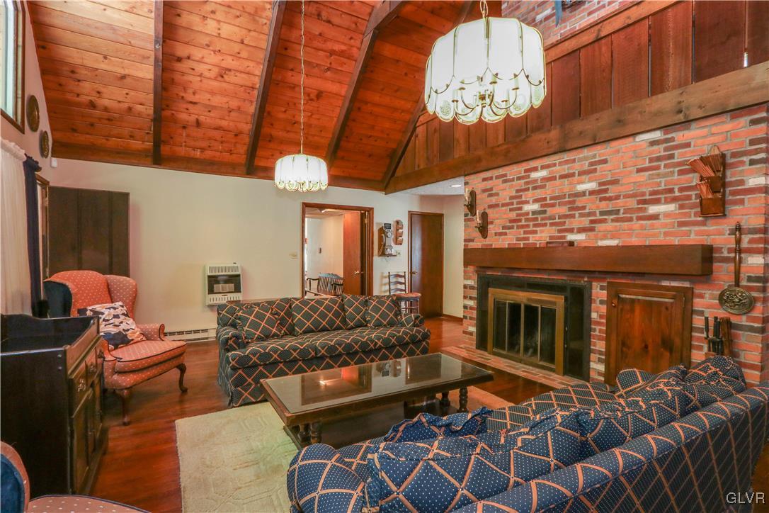 1271 Kilmer Road Tobyhanna, PA 18466 - Photo 8 of 36 a living room with furniture a chandelier and a fireplace