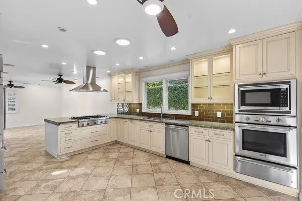 a kitchen with granite countertop a stove sink and microwave