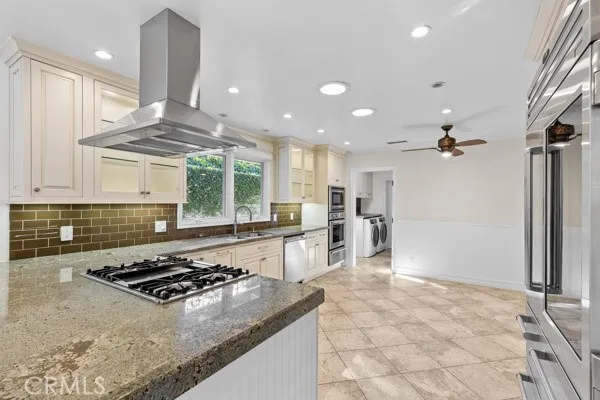 a kitchen with stainless steel appliances granite countertop a stove a sink and a refrigerator