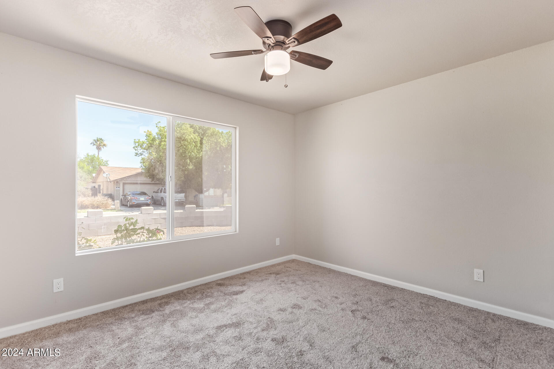 7231 West Flower Street Phoenix, AZ 85033 - Photo 13 of 22 an empty room with a window and a ceiling fan