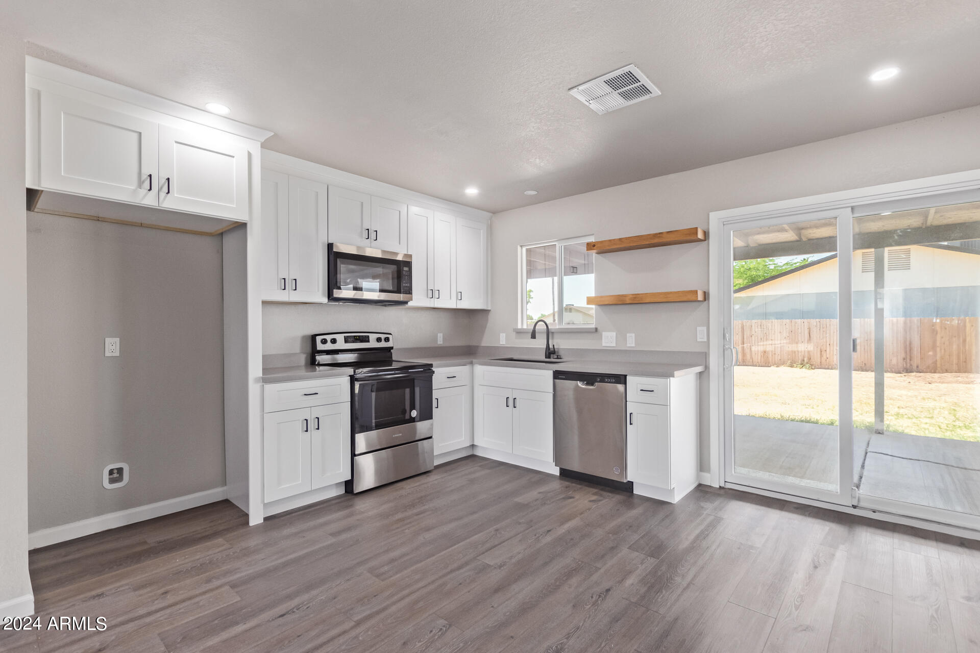 7231 West Flower Street Phoenix, AZ 85033 - Photo 4 of 22 a kitchen with a stove a sink and a refrigerator