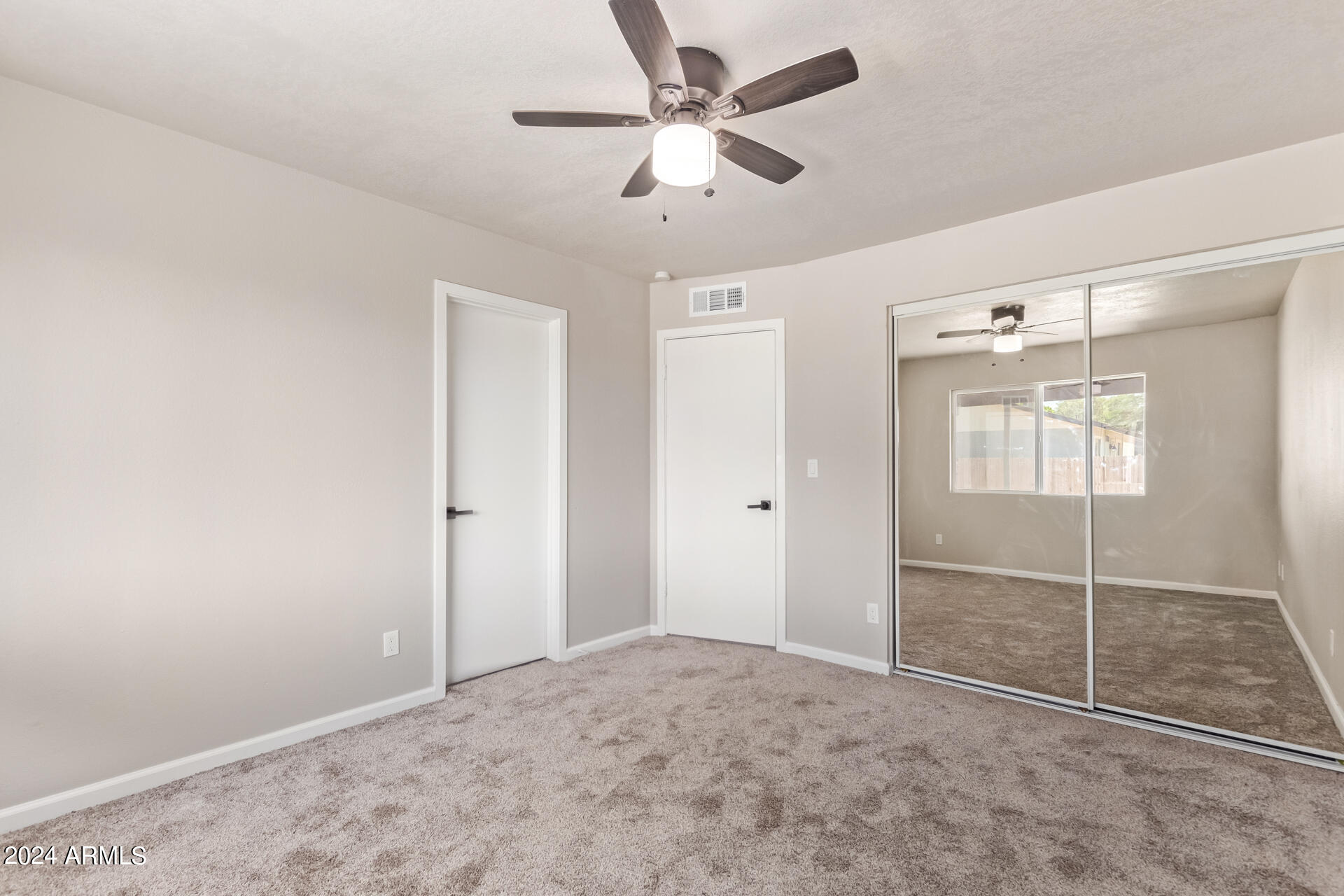 7231 West Flower Street Phoenix, AZ 85033 - Photo 9 of 22 a view of an empty room with a ceiling fan