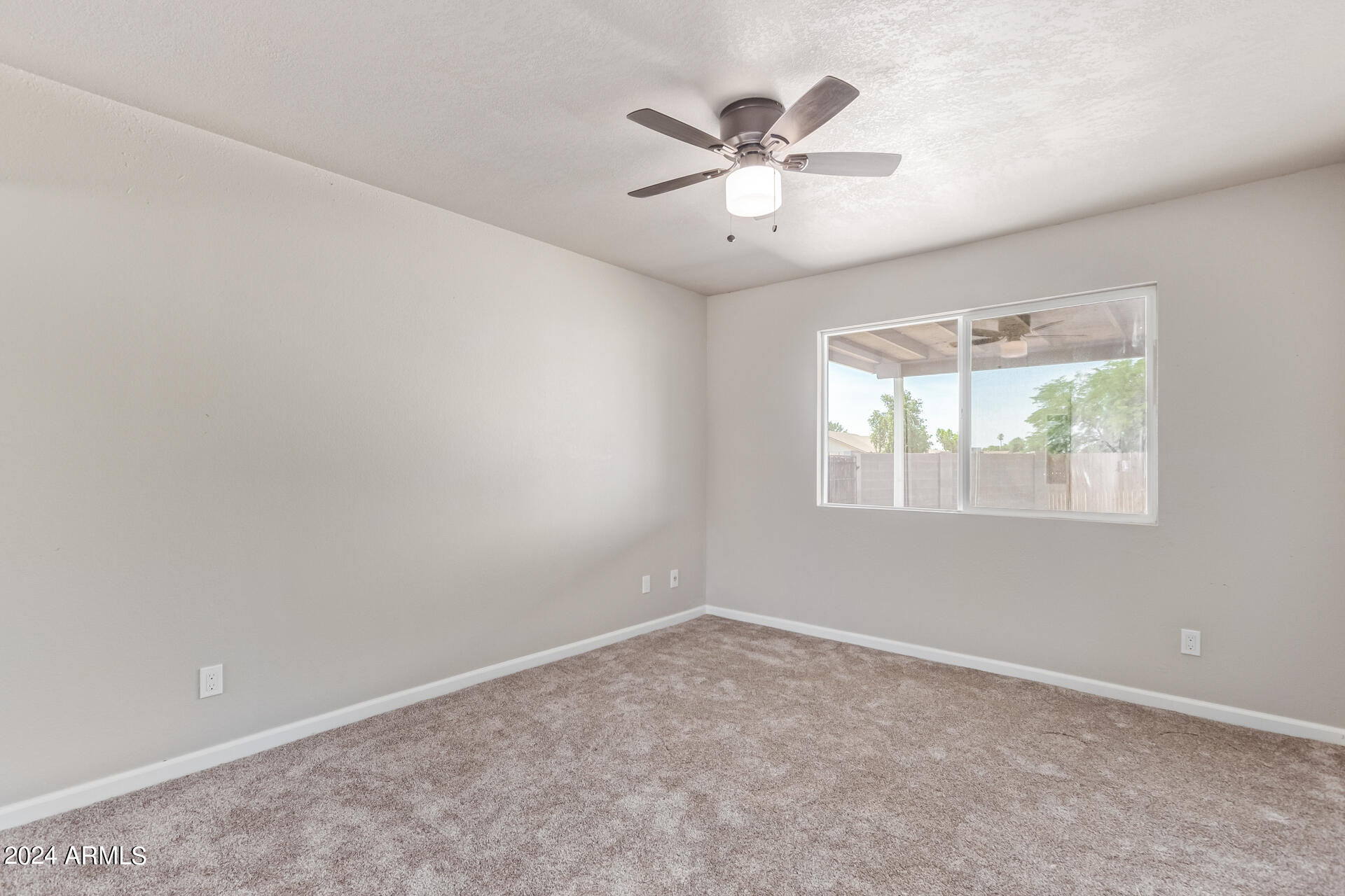7231 West Flower Street Phoenix, AZ 85033 - Photo 10 of 22 an empty room with windows and fan