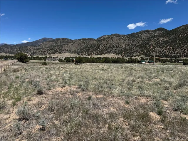 a view of a dry yard with mountains in the background