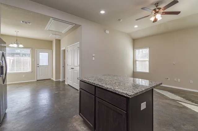 a kitchen with a sink granite counter top space and a window