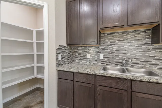 a kitchen with granite countertop a sink and cabinets