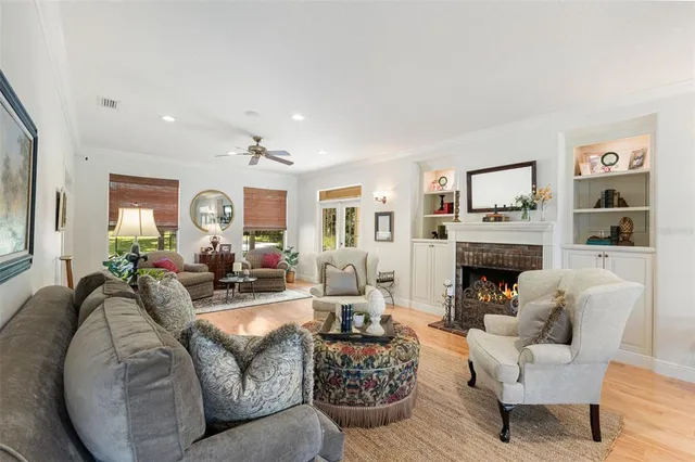 a kitchen with stainless steel appliances granite countertop a refrigerator a sink dishwasher a dining table and chairs with wooden floor