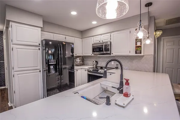 a kitchen with sink refrigerator and microwave