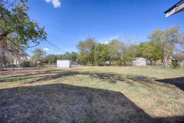 a view of dirt yard with a large trees