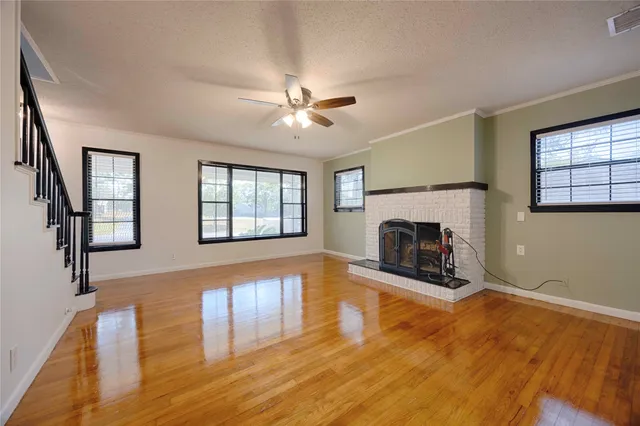 wooden floor fireplace and windows in an empty room