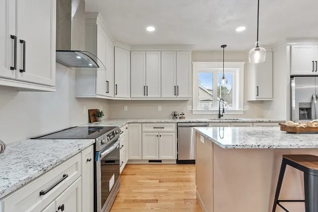 a kitchen with stainless steel appliances granite countertop a sink stove and refrigerator