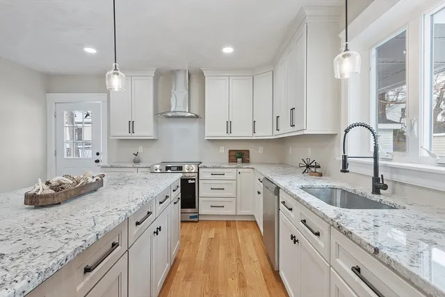a kitchen with granite countertop a sink stove and cabinets