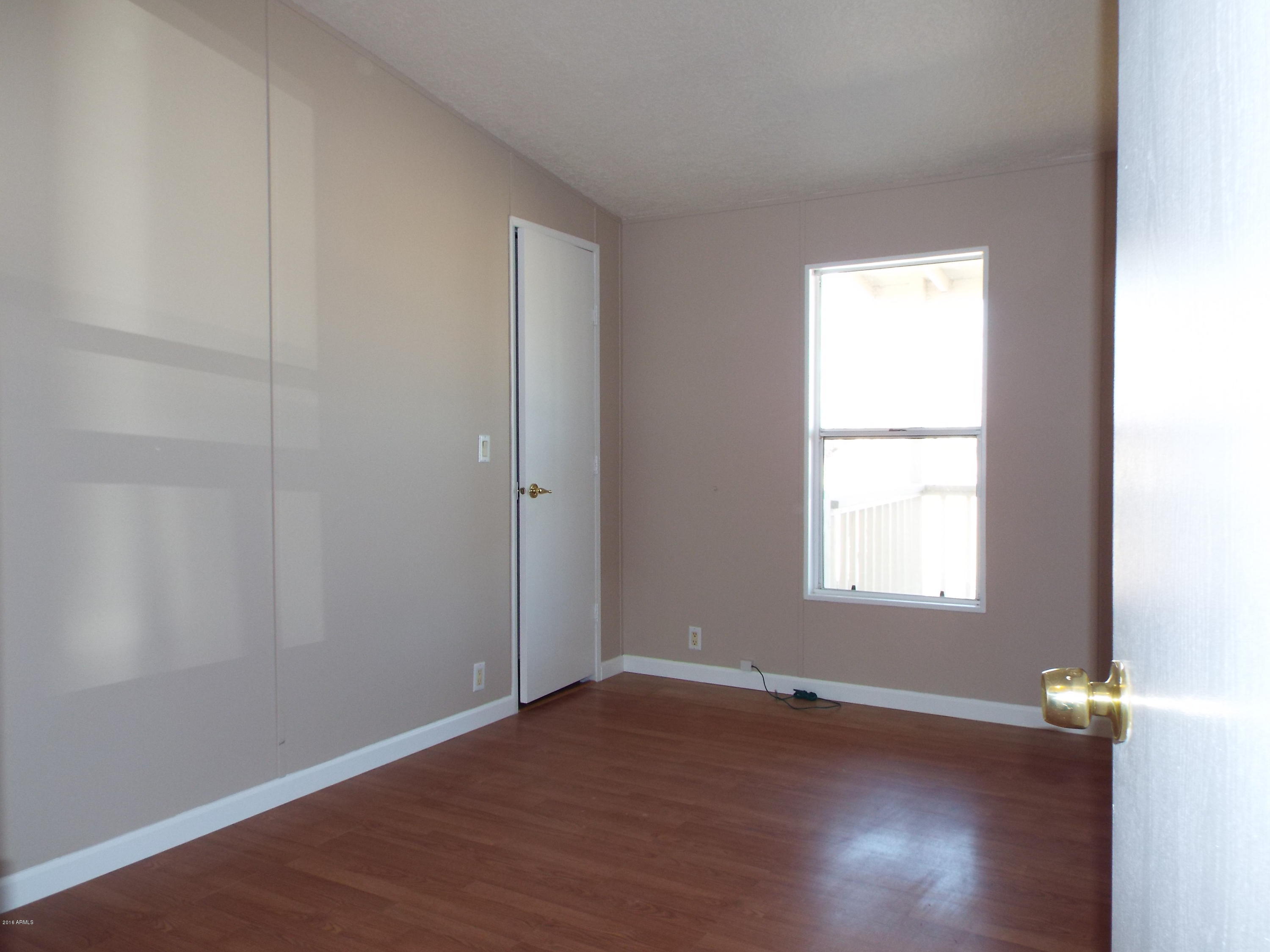 20843 West Teepee Road Buckeye, AZ 85326 - Photo 13 of 29 an empty room with wooden floor and windows