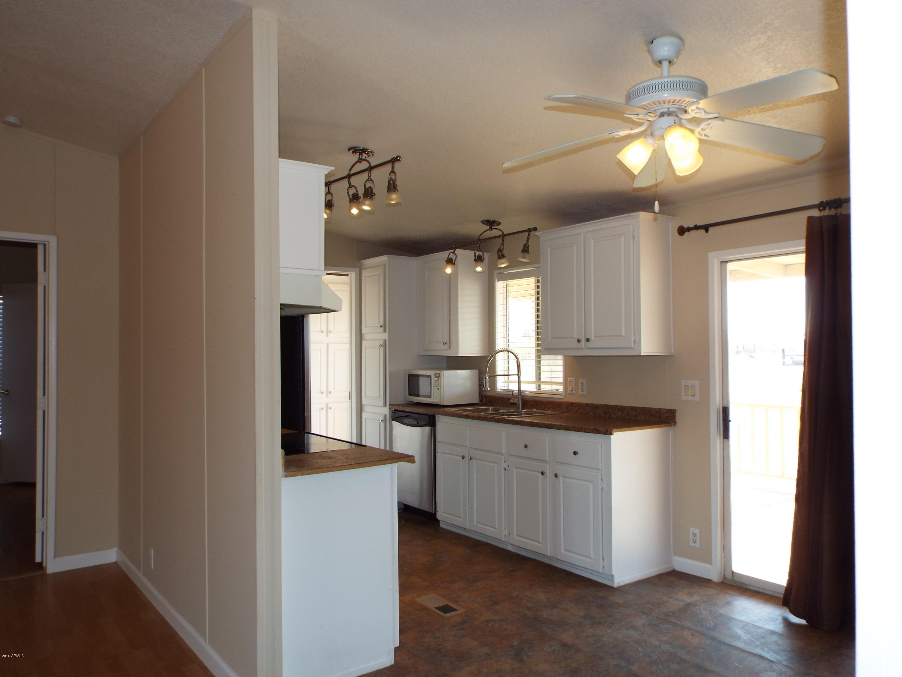 20843 West Teepee Road Buckeye, AZ 85326 - Photo 17 of 29 a kitchen with a sink a chandelier stainless steel appliances and cabinets
