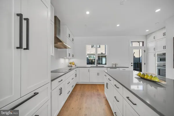 a large kitchen with stainless steel appliances granite countertop a sink and cabinets