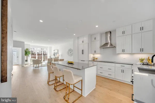 a large kitchen with stainless steel appliances lots of counter space and wooden floor