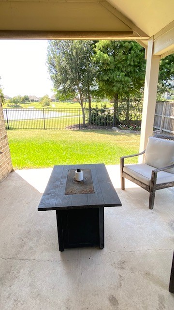 5002 Naples Grove Lane Rosharon, TX 77583 - Photo 30 of 38 Charming covered patio with a cozy seating area and fire pit, overlooking a lush green yard with scenic views.