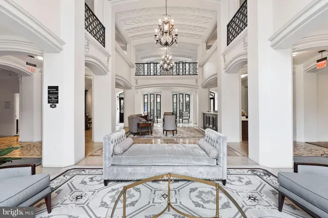 a living room with furniture a fireplace and a chandelier
