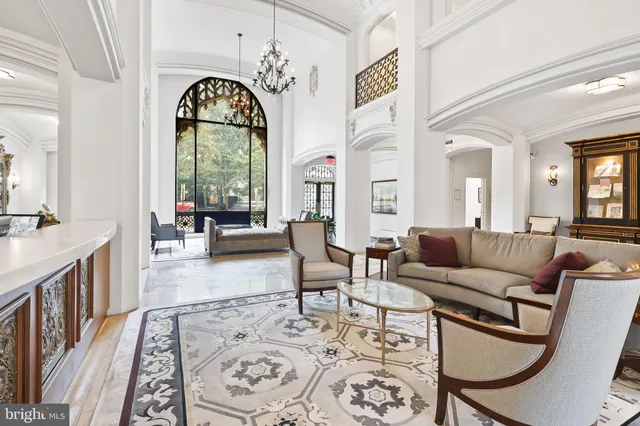 a living room with furniture a fireplace and a chandelier