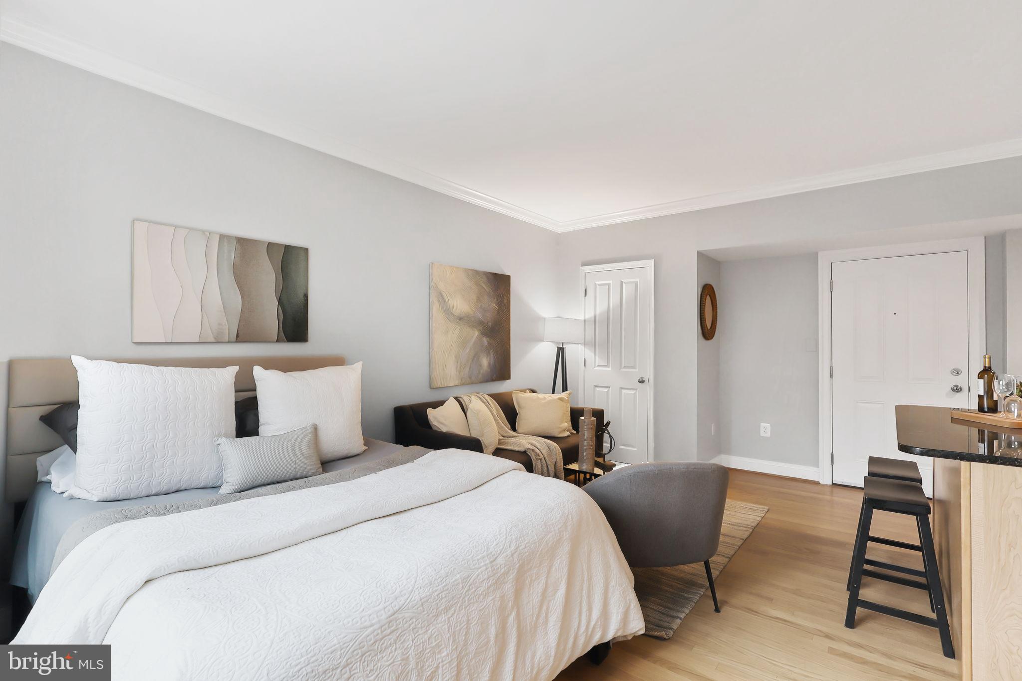 1701 16th Street Northwest, Unit 706 Washington, DC 20009 - Photo 6 of 29 a bedroom with a bed and a chair