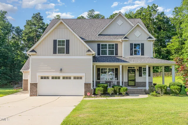 a front view of a house with a yard and potted plants