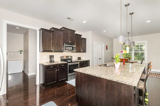 a kitchen with stainless steel appliances granite countertop a sink stove and refrigerator