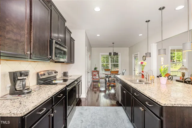 a kitchen with granite countertop a sink a counter top space appliances and cabinets