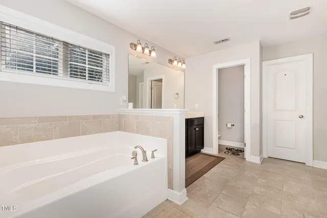 a spacious bathroom with a bathtub and a shower