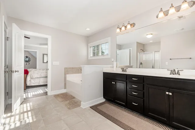 a spacious bathroom with a tub sink and mirror
